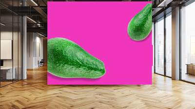 Pair of green whole fresh raw avocados on pink background with copy space for your text Wall mural