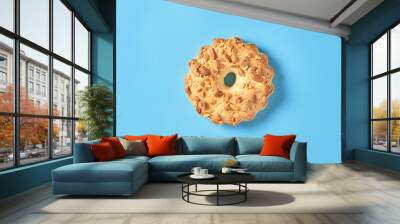 Single fresh circle oat cookie with hole and peanuts lies on blue desk on kitchen. Top view. Close-up Wall mural