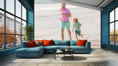 active family of daddy man and child boy running on beach together, togetherness Wall mural