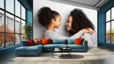 African american mother with her daughter looking and smiling at each other. Wall mural