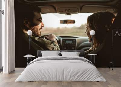 Happy couple in a car looking at each other. Wall mural