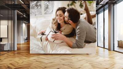 Young couple in love make a present to each other. Wall mural