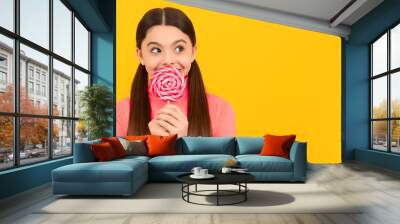 dreamy kid with lollipop candy on stick on yellow background, caramel. Teenager child with sweets, poster banner header, copy space. Wall mural