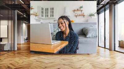 Beautiful young black woman has a zoom call or works in from laptop online Wall mural