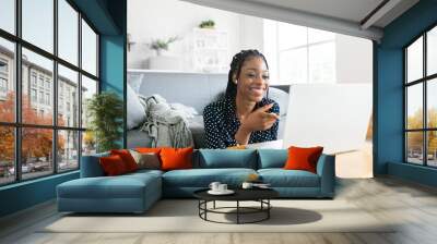 Beautiful young black woman has a zoom call remote work or study online in from laptop classes Wall mural