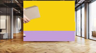 Giving a delivery package or a gift from the screen of the computer online yellow and purple background Wall mural