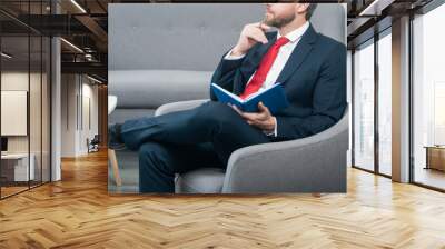 mature businessman in suit sit in reading-room making notes in notebook Wall mural