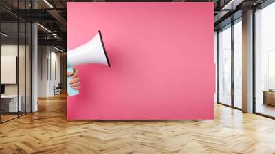 Megaphone in woman hand on a pink background. Copy space. Place for text. Generative AI Wall mural