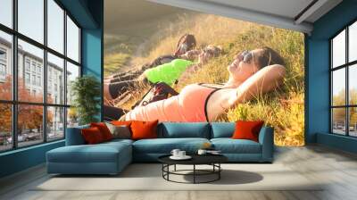 A happy woman in the mountains sleeps with pleasure and basks in the sun. Wall mural