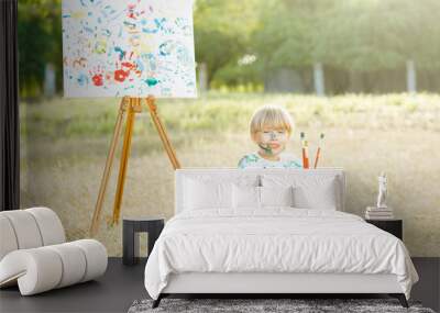 Little pretty boy with painting brushes outdoor. Child painter. Kid drawing. Adorable boy outdoor in the park. Little artist. Wall mural