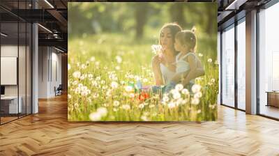 Portrait of happy mother and her little child on spring background. Cheerful family at dandelion field.Mom and her cute daughter outdoors. Wall mural