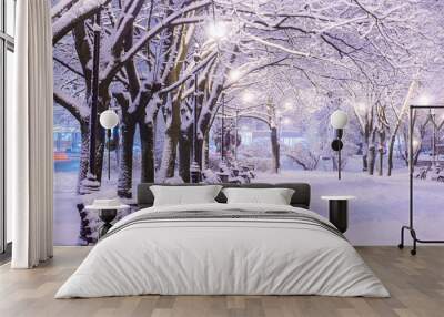 Amazing winter night landscape of snow covered bench among snowy trees and shining lights during the snowfall. Artistic picture. Beauty world. Wall mural