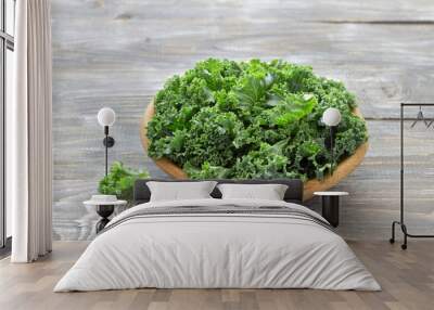 Fresh green curly kale leaves on a wooden table. selective focus. rustic style. healthy vegetarian food Wall mural