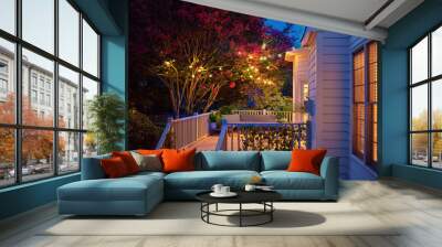 beautifully lit exterior of traditional house with wooden terrace and blooming crape myrtle in summer garden at night Wall mural