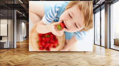 cute happy kid eating tasty ripe strawberries Wall mural