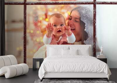 cute infant baby girl in mother hand looking through the window, family winter holidays Wall mural