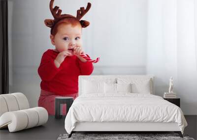 cute little redhead baby boy with reindeer band tasting christmas sweet treats, sitting on the floor at home Wall mural