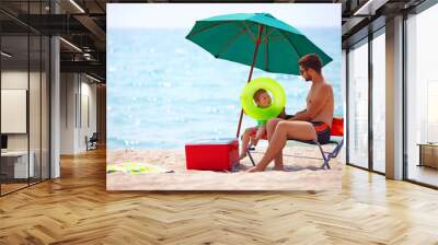 father and son relaxing on sea beach Wall mural