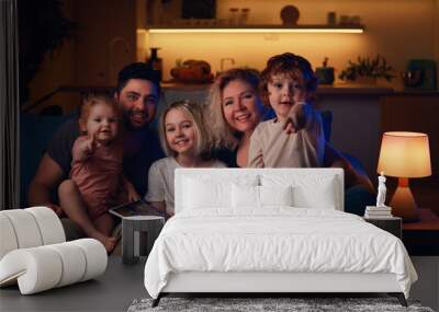 happy family sitting together at cozy home in the evening Wall mural