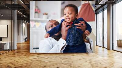 happy infant baby boy in father's strong hands, having fun together Wall mural