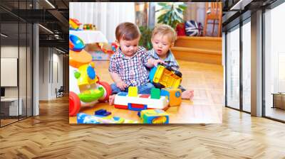 two cute baby toddlers playing in nursery room Wall mural