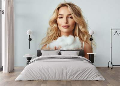 Young beautiful woman in a small top holding a cloud in her hands, on a white background Wall mural