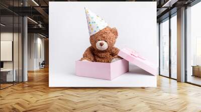 a teddy bear in a pink gift box celebrates a birthday on a white background, isolated Wall mural