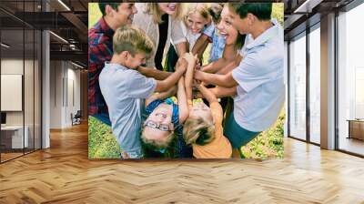 Excited children team heaping hands in summer Wall mural