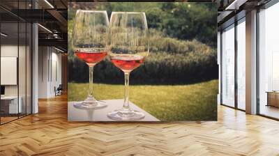 Two glasses of rose wine on a white table in garden at vintage style Wall mural