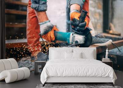 a man is sawing metal with an angle grinder. Wall mural