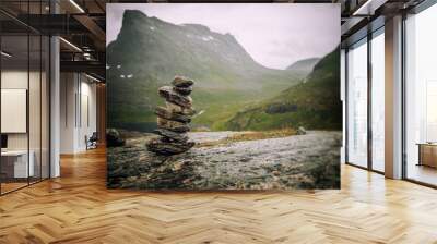 A cairn of stones on a background of mountains, an amazing landscape in the mountains of Norway, a trip to Scandinavia, a landscape of northern nature Wall mural