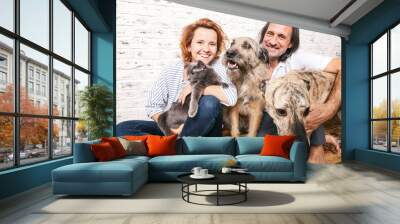 Attractive man and his young wife with pets, two dogs and a cat, a family portrait Wall mural