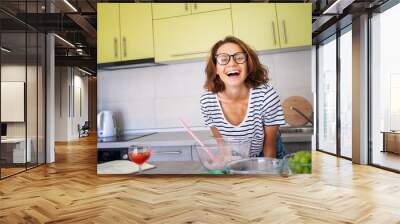 Beautiful happy young woman preparing dessert at home in the kitchen laughing joyfully, hobbies and entertainment, food concept Wall mural