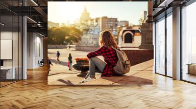 Beautiful woman in the background of a European city in the sun at sunset, student and traveler, vacation in the city, Moscow, Russia Wall mural