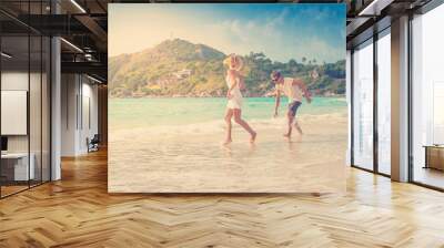 beautiful young couple walking along the shore of a tropical sea Wall mural