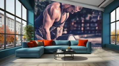 Cute young European man doing strength fitness workout, healthy lifestyle sport concept, weight lifting barbell analogs Wall mural