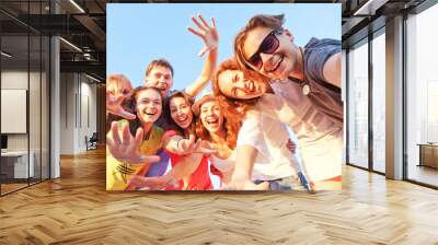 group of happy young friends doing selfie against the blue sky. Wall mural