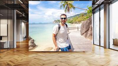 Handsome happy man wearing white T-shirt at the sea or the ocean background. Travel vacation holiday. Man walking at the sea, enjoy tropical season. Relax mix raced  adult man Wall mural