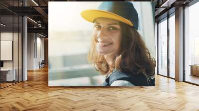 portrait of a beautiful smiling girl with wavy hair in a baseball cap Wall mural