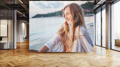 Portrait of an attractive young woman with long hair on the sea shore Wall mural