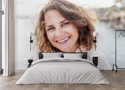 Portrait of happy young beautiful girl close-up, shot of head. A girl looks at the camera with a natural happy smile Wall mural