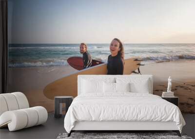 Young couple of happy smiling surfers on ocean coast, sport active lifestyle vacation travel concept Wall mural