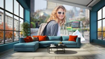 young woman with a city map and a backpack Wall mural