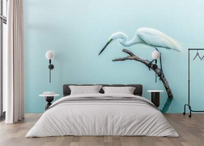   A bird perched on a tree over water with a fish in its beak Wall mural