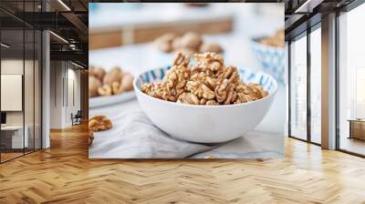   A bowl brimming with nuts rests beside two bowls of walnuts Wall mural