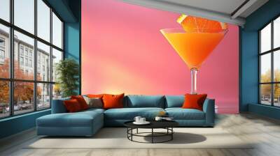   A glass containing a close-up of an orange slice on top, against a pink background Wall mural