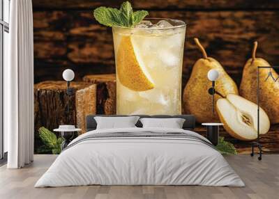   A glass of ice tea with a pear slice and mint on a wooden table beside two pears Wall mural