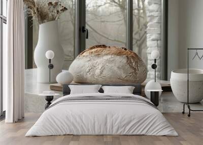   A loaf of bread atop a wooden cutting board Nearby, a white vase and two pristine eggs Wall mural