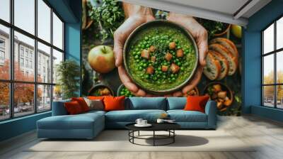   A person holding a bowl of peas and croutons in front of a bountiful table of fruits and vegetables Wall mural