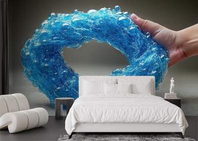   Hand holding transparent blue plastic bubble with water bubbles inside Wall mural